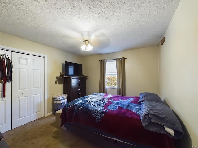 carpeted bedroom with ceiling fan, a closet, and a textured ceiling