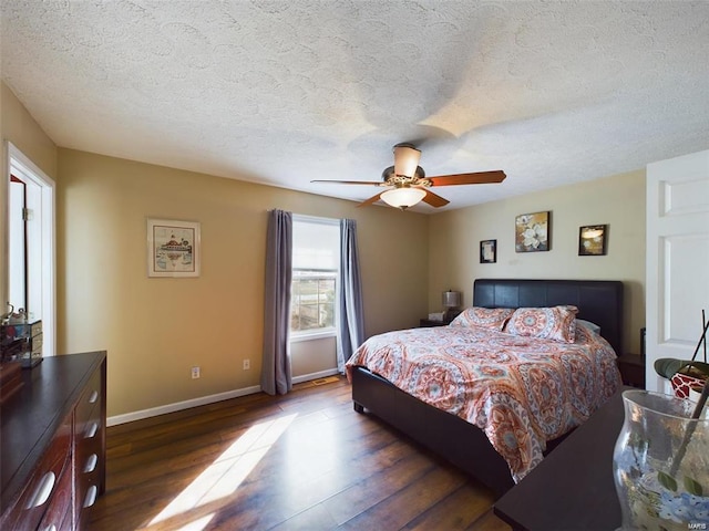 bedroom featuring dark wood-type flooring, ceiling fan, and a textured ceiling