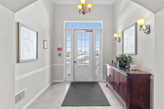 foyer entrance featuring light tile patterned floors, an inviting chandelier, and ornamental molding