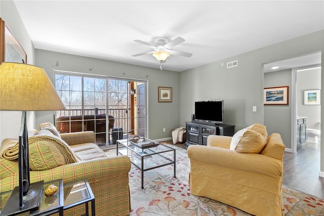 living room with ceiling fan and light hardwood / wood-style flooring