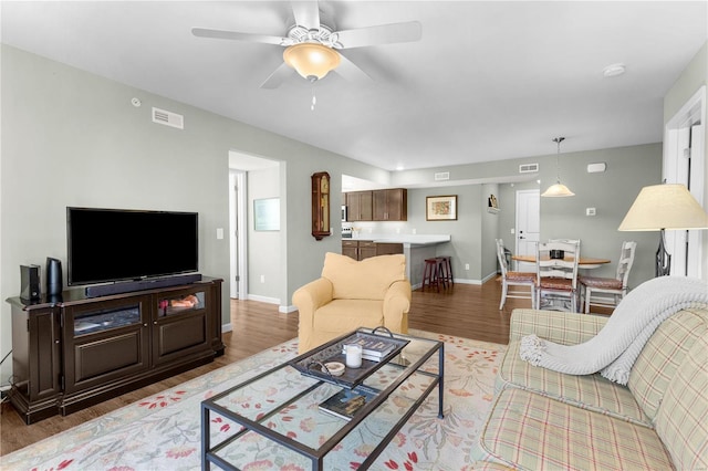 living room with light hardwood / wood-style floors and ceiling fan