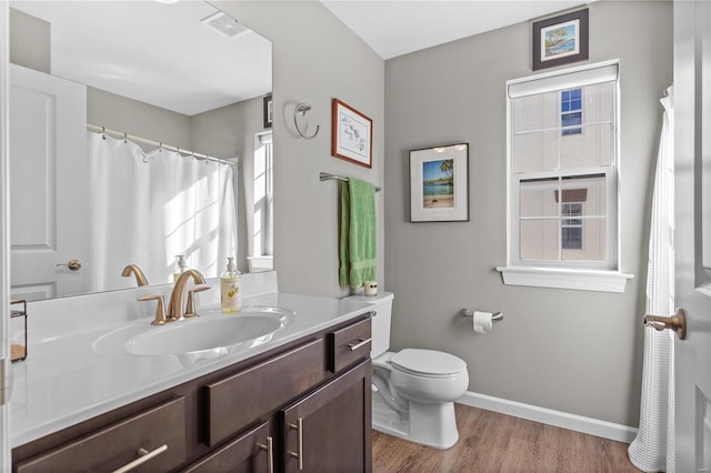 bathroom featuring toilet, hardwood / wood-style flooring, and vanity