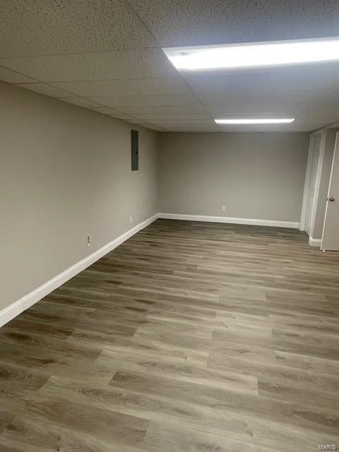 basement with a drop ceiling and hardwood / wood-style flooring