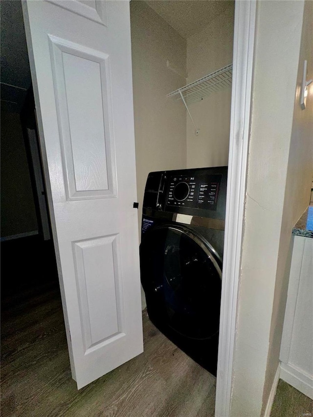 laundry area featuring washer / dryer and dark wood-type flooring