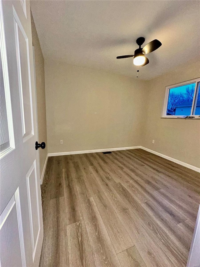 spare room featuring wood-type flooring and ceiling fan