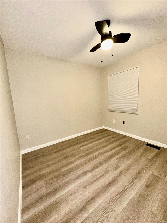 spare room featuring wood-type flooring and ceiling fan