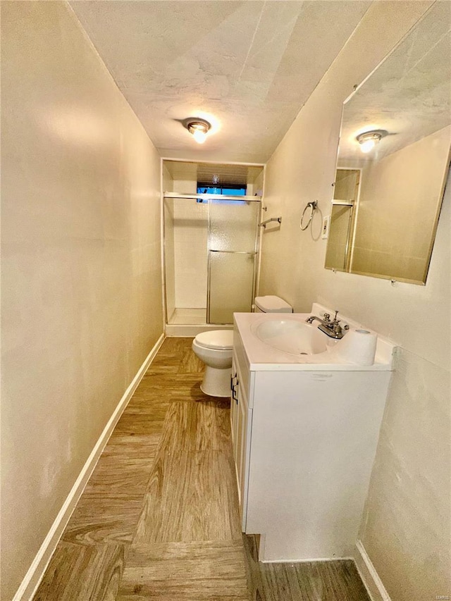 bathroom with wood-type flooring, toilet, an enclosed shower, and a textured ceiling