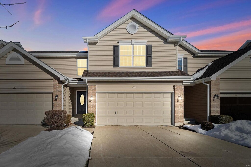 view of front of home featuring concrete driveway and brick siding