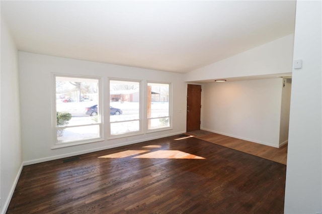 unfurnished room with dark hardwood / wood-style floors and vaulted ceiling