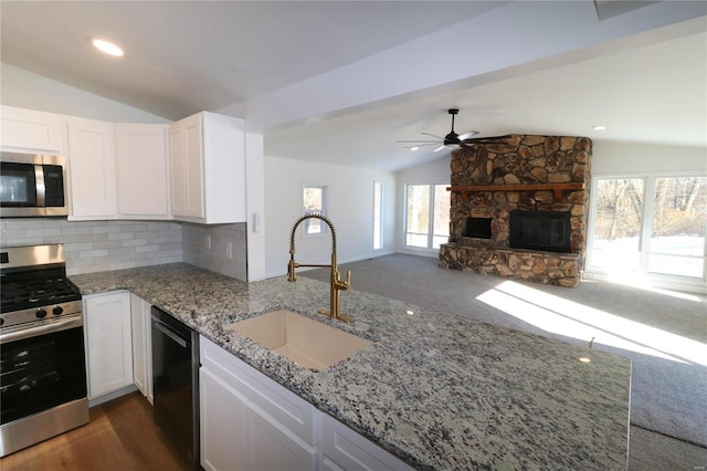 kitchen featuring ceiling fan, appliances with stainless steel finishes, tasteful backsplash, white cabinets, and sink