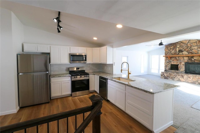 kitchen with white cabinets, kitchen peninsula, sink, and stainless steel appliances