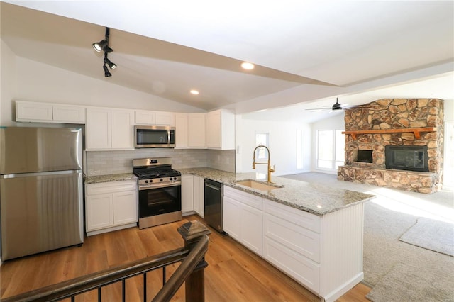 kitchen with white cabinets, kitchen peninsula, sink, and stainless steel appliances