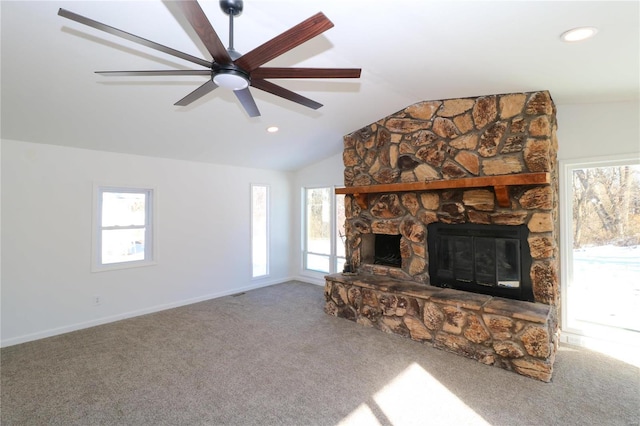 unfurnished living room with a stone fireplace, ceiling fan, a healthy amount of sunlight, carpet floors, and lofted ceiling