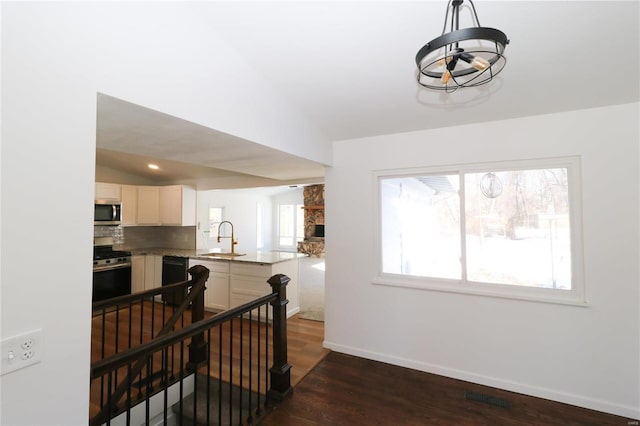 interior space featuring vaulted ceiling, appliances with stainless steel finishes, sink, and dark hardwood / wood-style floors