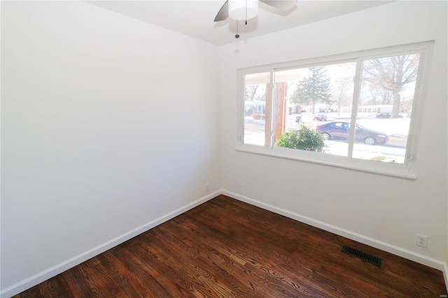 spare room featuring ceiling fan and dark wood-type flooring