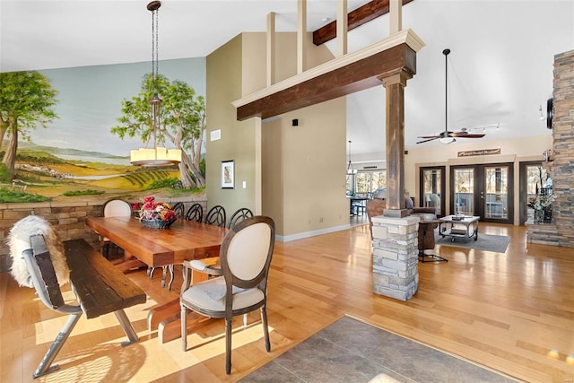 dining space with high vaulted ceiling, light hardwood / wood-style floors, ceiling fan, and ornate columns