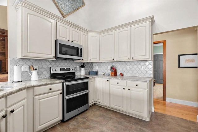 kitchen featuring white cabinetry, stainless steel appliances, and backsplash