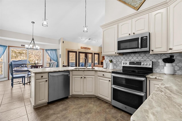 kitchen featuring hanging light fixtures, plenty of natural light, sink, and appliances with stainless steel finishes