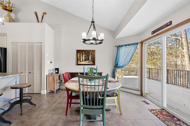 dining space featuring tile patterned flooring, a notable chandelier, and high vaulted ceiling