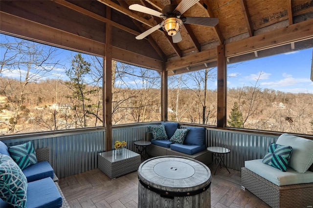 sunroom / solarium with vaulted ceiling, a wealth of natural light, and ceiling fan