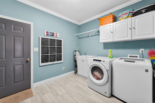 laundry room with sink, crown molding, cabinets, and washing machine and clothes dryer