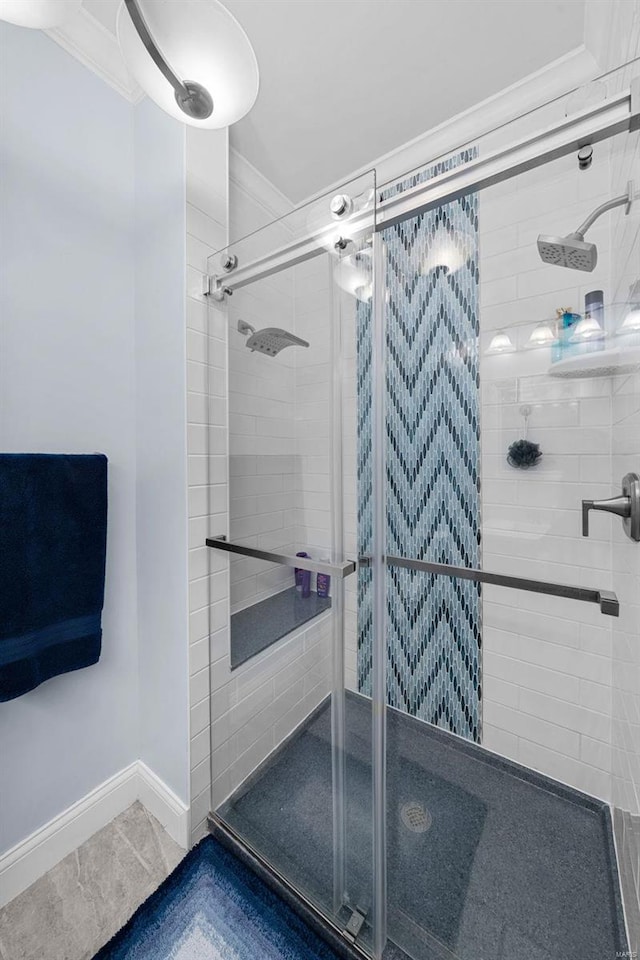 bathroom with ornamental molding and an enclosed shower