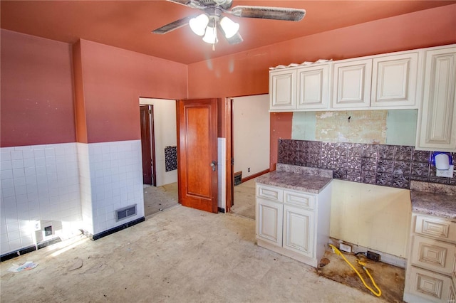 kitchen with ceiling fan and tile walls