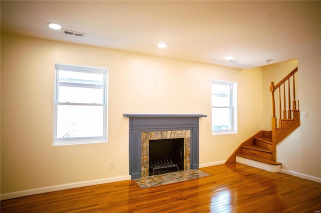 unfurnished living room featuring hardwood / wood-style floors and a high end fireplace