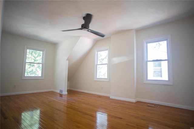 bonus room featuring ceiling fan, a healthy amount of sunlight, and hardwood / wood-style flooring