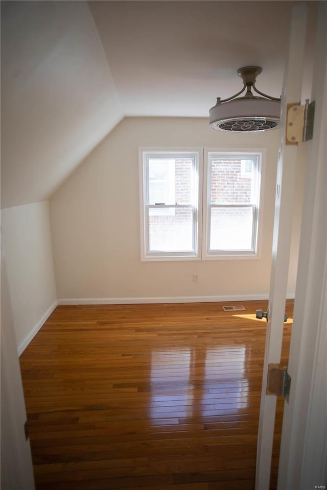 bonus room with lofted ceiling and hardwood / wood-style floors