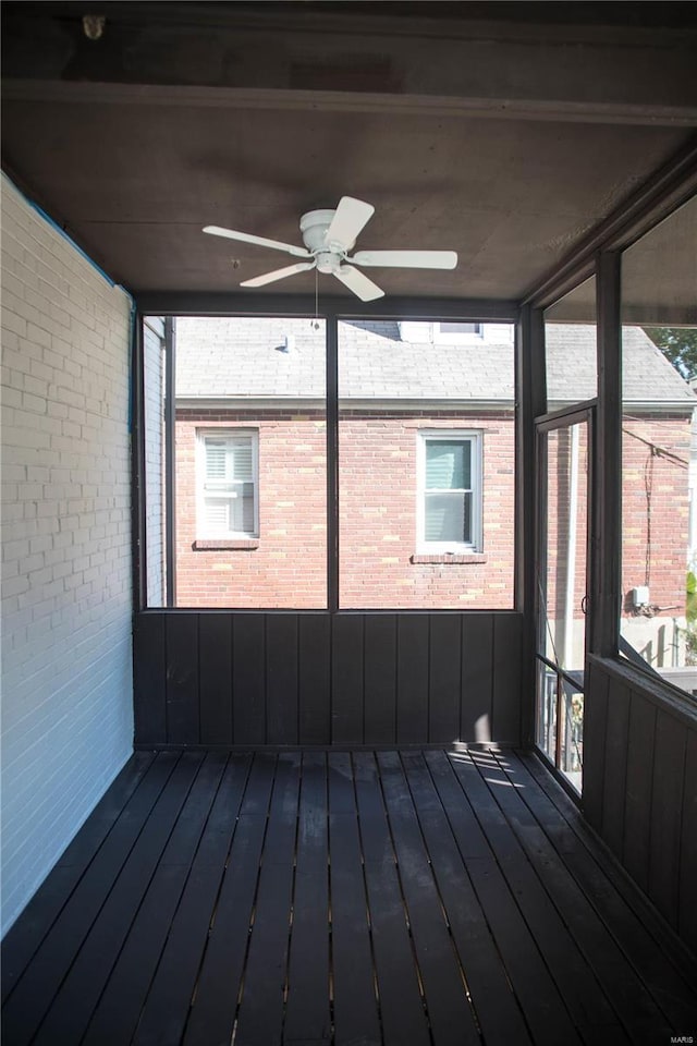 unfurnished sunroom featuring ceiling fan and a healthy amount of sunlight