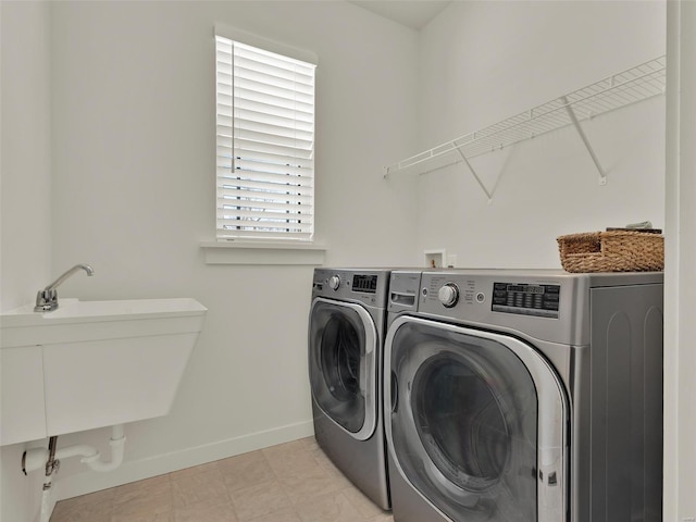 laundry area with a sink, laundry area, baseboards, and washer and dryer