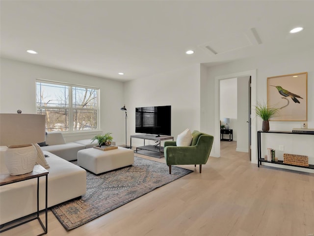 living area with light wood-type flooring, attic access, and recessed lighting