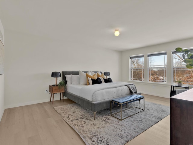 bedroom featuring light wood-style floors and baseboards