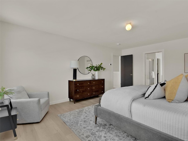 bedroom featuring baseboards and light wood finished floors