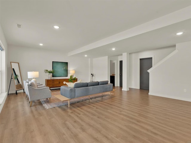 living room with light wood-style floors, visible vents, and recessed lighting