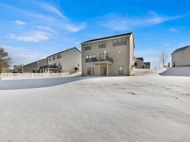 snow covered property featuring fence and a residential view