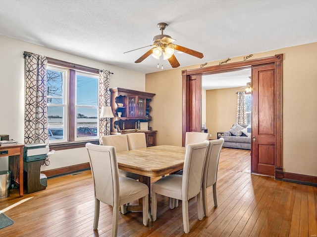 dining room featuring ceiling fan, a textured ceiling, and light wood-type flooring