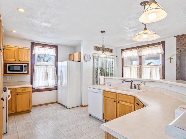 kitchen with sink, a textured ceiling, white appliances, and decorative light fixtures