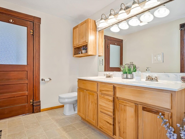 bathroom with tile patterned flooring, vanity, and toilet