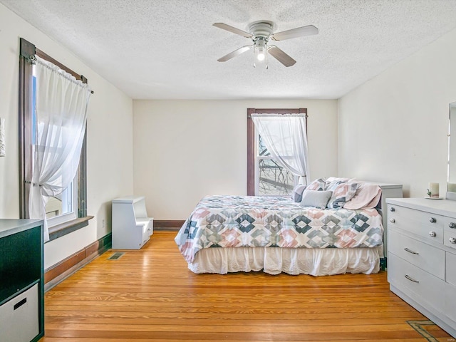 bedroom featuring ceiling fan, a textured ceiling, and light wood-type flooring