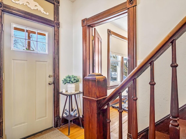 entrance foyer featuring stairway and wood finished floors