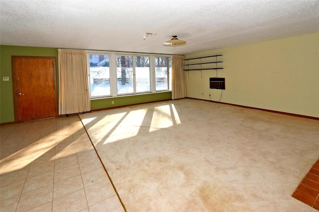 unfurnished room featuring a textured ceiling, light tile patterned floors, and heating unit