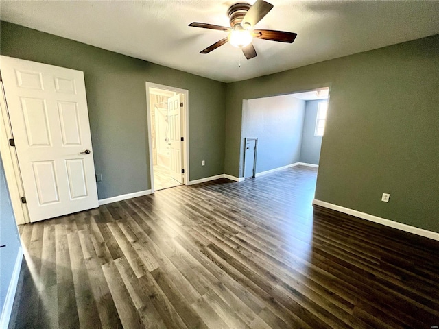 unfurnished bedroom with dark wood-type flooring, ceiling fan, and connected bathroom