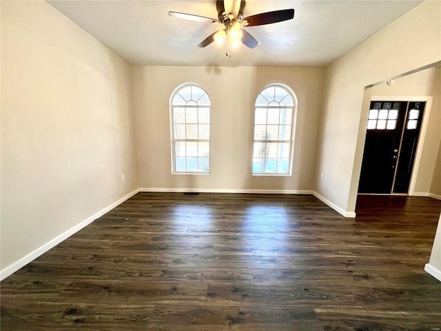 empty room featuring dark wood-type flooring and ceiling fan