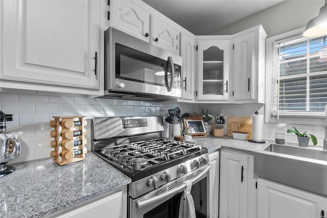 kitchen with sink, white cabinetry, stainless steel appliances, and tasteful backsplash