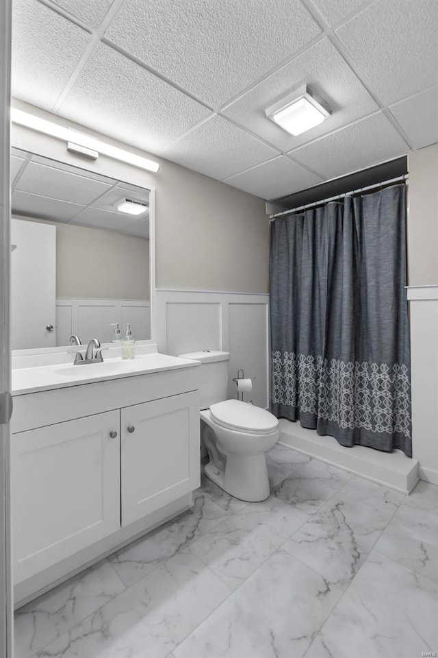 full bathroom featuring toilet, vanity, a paneled ceiling, and shower / bath combination with curtain