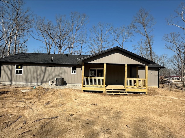 back of house with central AC unit and roof with shingles