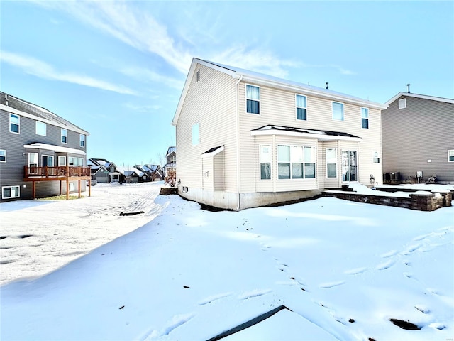 view of snow covered back of property