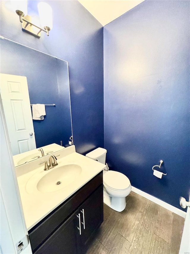 bathroom featuring toilet, vanity, and hardwood / wood-style floors